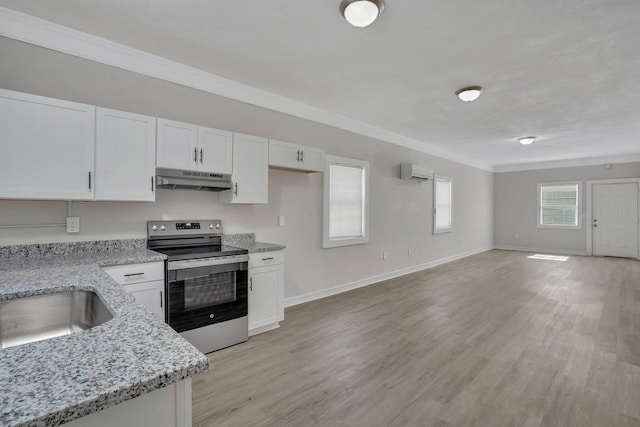 kitchen with light stone countertops, an AC wall unit, light hardwood / wood-style flooring, and stainless steel electric stove