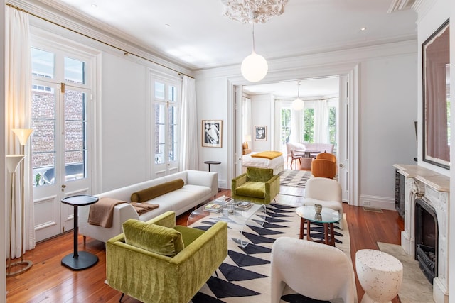 155 Wentworth St Unit A, Charleston, SC 29401 - living room featuring light wood-style floors, a fireplace with flush hearth, baseboards, and crown molding