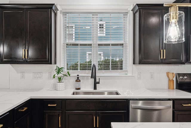 kitchen with appliances with stainless steel finishes, tasteful backsplash, sink, dark brown cabinetry, and light stone countertops