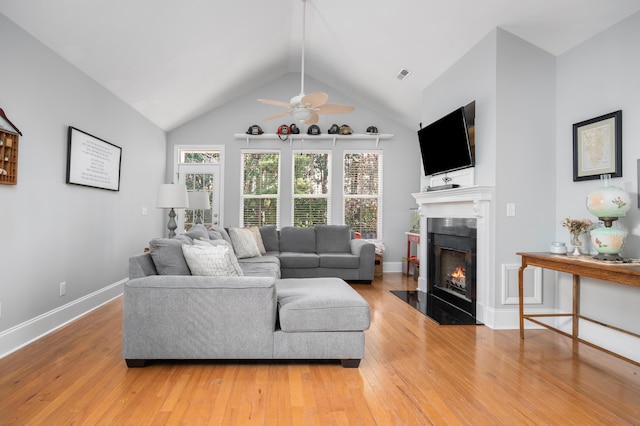 living room featuring lofted ceiling, ceiling fan, and wood-type flooring