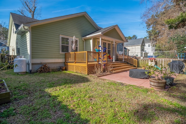 back of house with a patio, a lawn, and a wooden deck