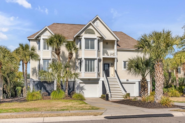 coastal inspired home featuring a garage and a balcony