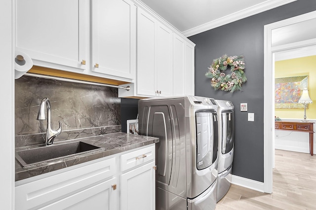 3115 Cross Vine Ln, Summerville, SC 29483 - laundry room with crown molding, baseboards, light wood-style flooring, washer and dryer, and a sink