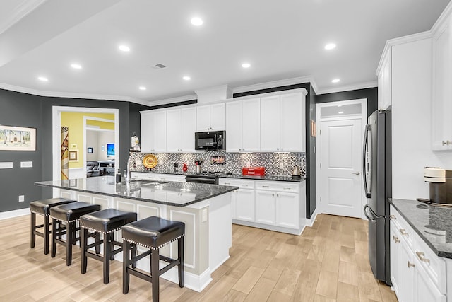 3115 Cross Vine Ln, Summerville, SC 29483 - kitchen featuring freestanding refrigerator, tasteful backsplash, visible vents, and black microwave