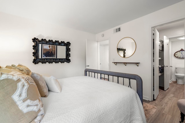 bedroom featuring light hardwood / wood-style flooring and ensuite bathroom