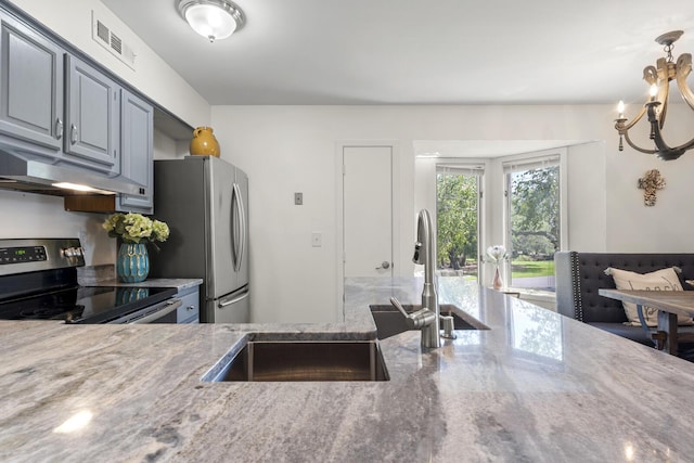 1647 Live Oak Park, Seabrook Island, SC 29455 - kitchen featuring appliances with stainless steel finishes, stone counters, a sink, a chandelier, and under cabinet range hood