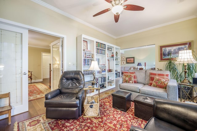 living room with crown molding, ceiling fan, and wood finished floors