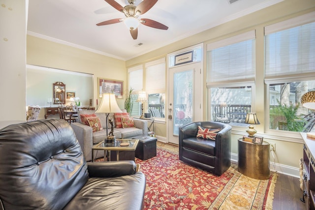 living area featuring ornamental molding, baseboards, a ceiling fan, and wood finished floors