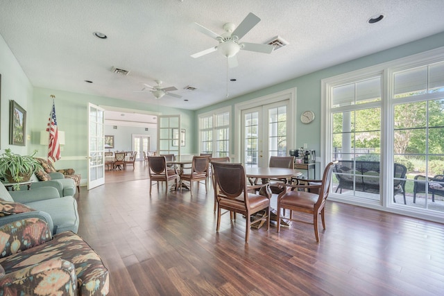 dining area with dark wood-type flooring, visible vents, a textured ceiling, and ceiling fan