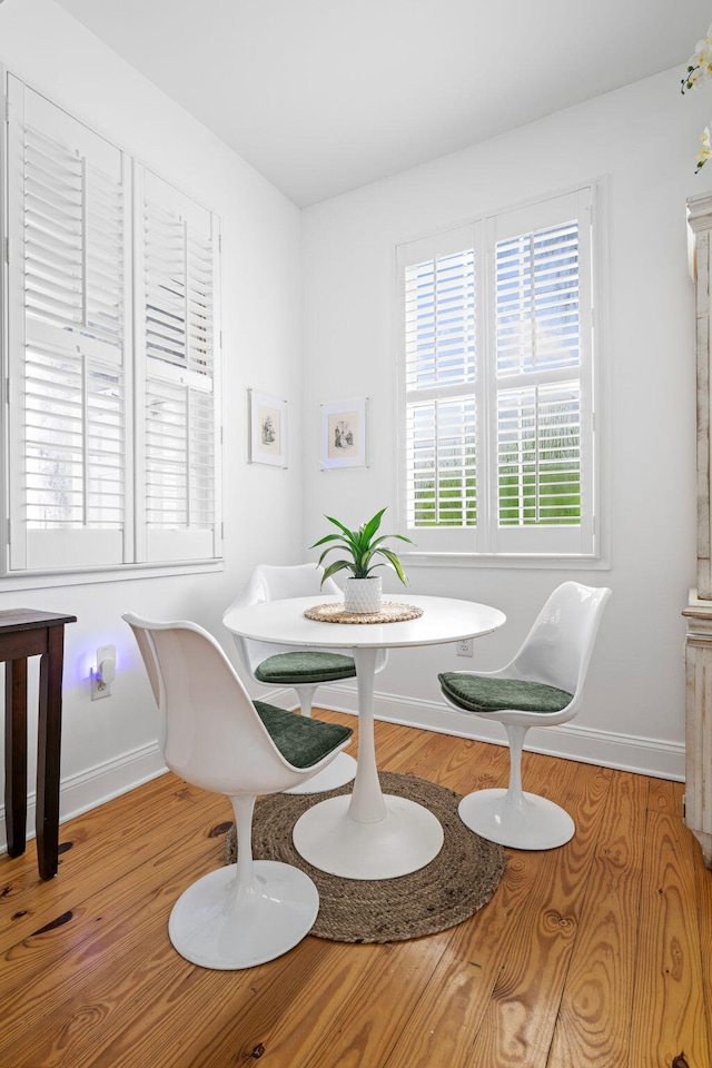 dining space with breakfast area, light wood-style flooring, and baseboards