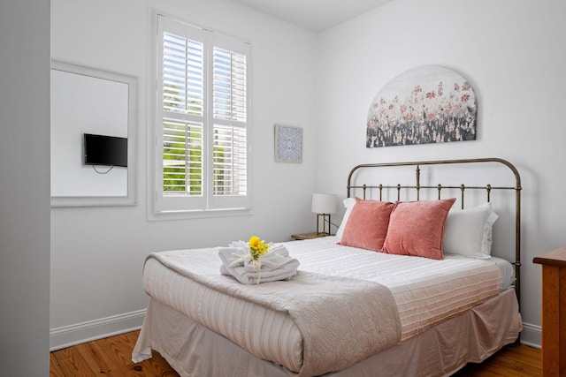 bedroom featuring wood finished floors and baseboards