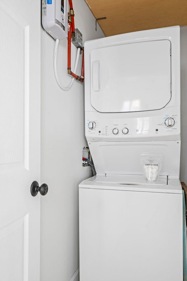 laundry room with stacked washer and clothes dryer and laundry area