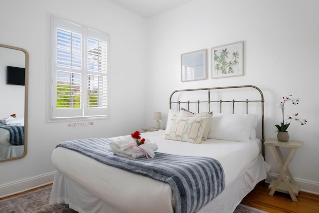 bedroom with dark wood finished floors and baseboards