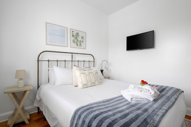 bedroom with baseboards and wood finished floors