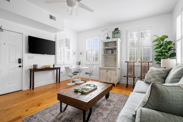 living area with a healthy amount of sunlight, light wood finished floors, and visible vents