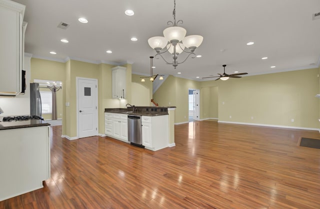 kitchen with white cabinetry, appliances with stainless steel finishes, pendant lighting, ceiling fan with notable chandelier, and sink