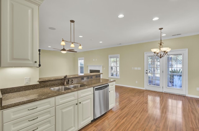 kitchen featuring decorative light fixtures, sink, white cabinets, and dishwasher