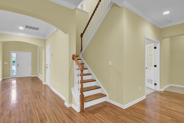 foyer with wood-type flooring and ornamental molding