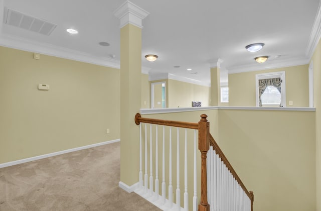 hallway featuring crown molding, light colored carpet, and decorative columns