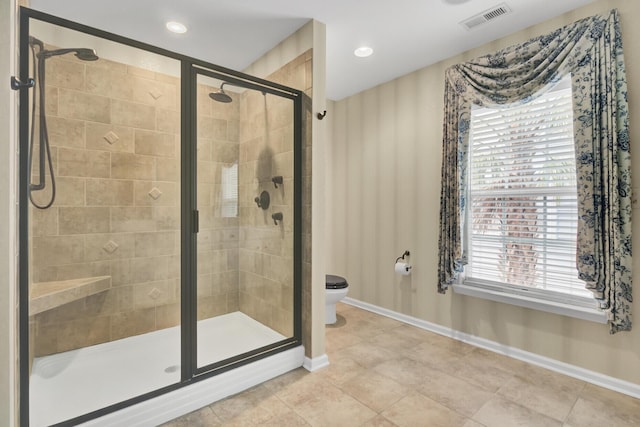 bathroom with toilet, tile patterned floors, and a shower with door