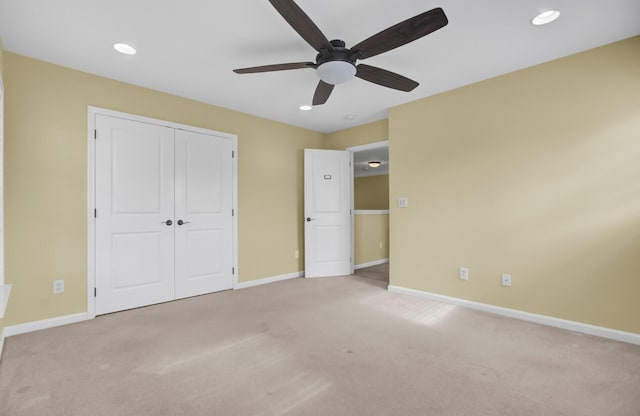 unfurnished bedroom featuring ceiling fan, light carpet, and a closet