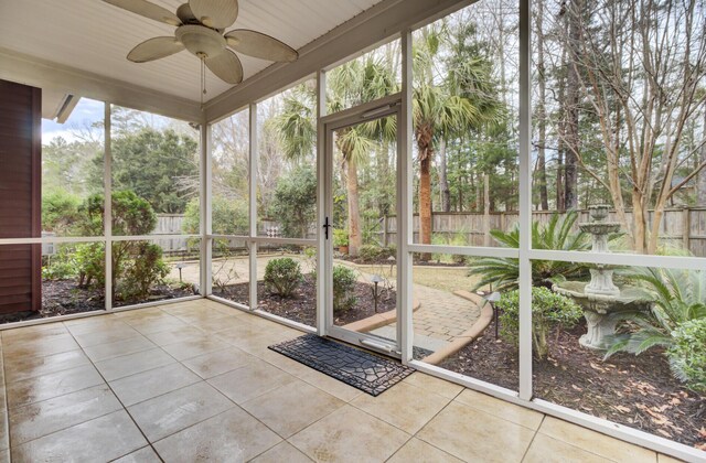 unfurnished sunroom featuring ceiling fan