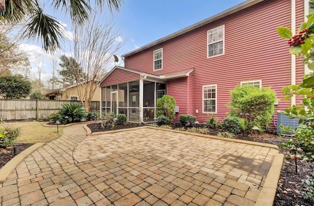 back of property featuring a sunroom and a patio