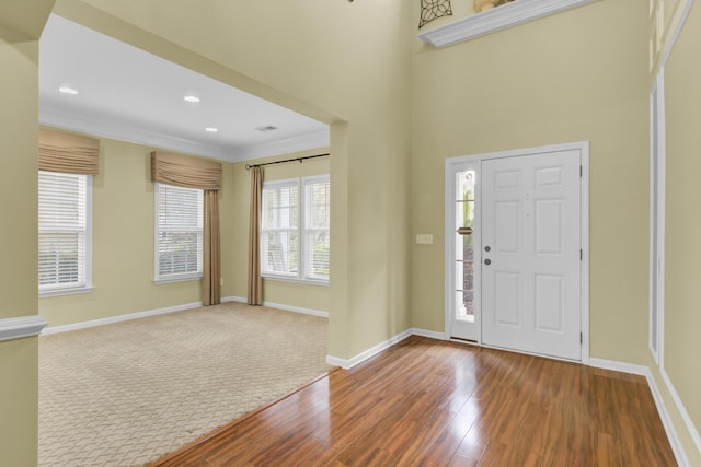 entrance foyer with ornamental molding and hardwood / wood-style flooring