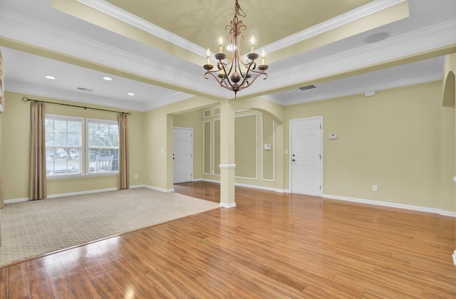 unfurnished room featuring a chandelier, light wood-type flooring, and ornamental molding