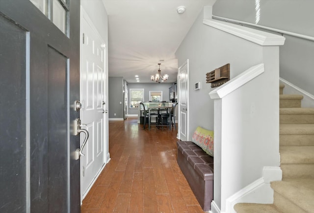 foyer with dark hardwood / wood-style flooring and a notable chandelier