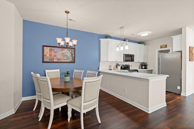 dining space with dark hardwood / wood-style floors and a chandelier