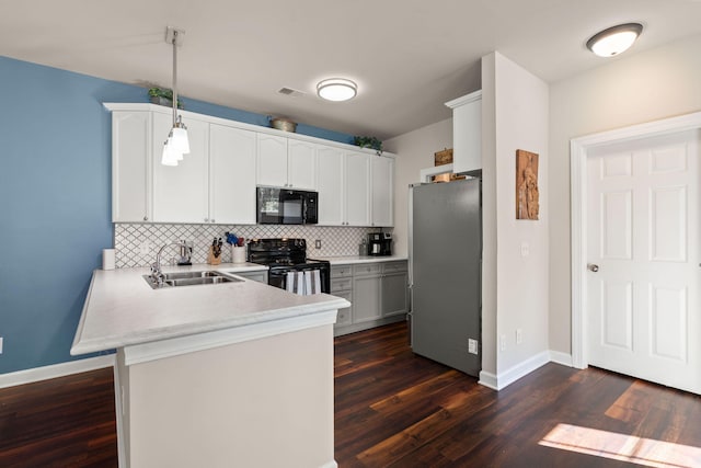 kitchen with kitchen peninsula, black appliances, dark wood-type flooring, sink, and decorative light fixtures