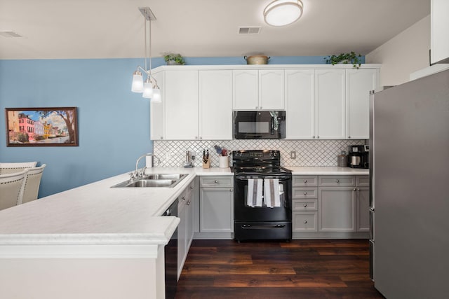 kitchen featuring black appliances, sink, pendant lighting, white cabinets, and dark wood-type flooring