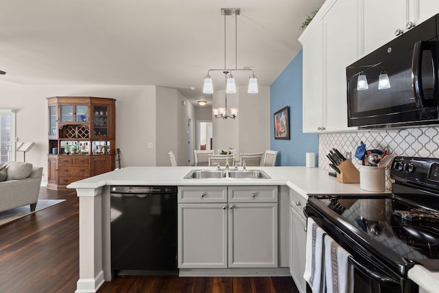 kitchen featuring kitchen peninsula, sink, black appliances, white cabinets, and dark hardwood / wood-style flooring