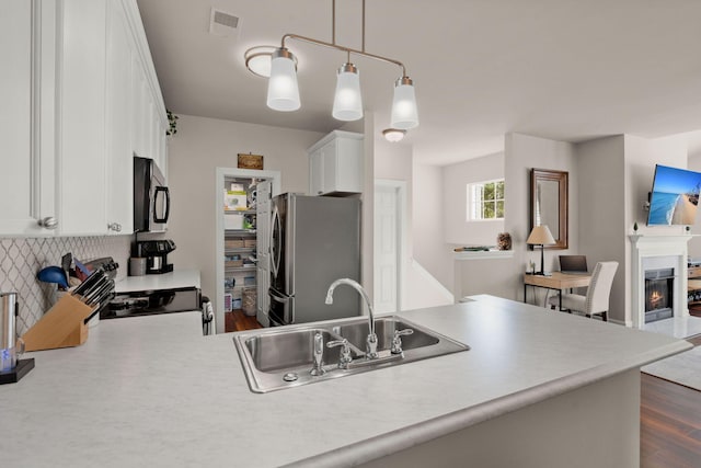 kitchen featuring hanging light fixtures, appliances with stainless steel finishes, white cabinetry, dark hardwood / wood-style floors, and sink