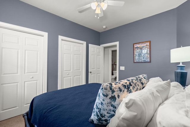 carpeted bedroom with two closets and ceiling fan