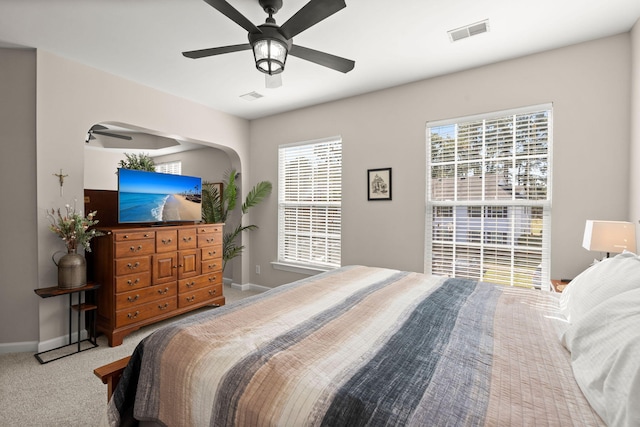 carpeted bedroom featuring multiple windows and ceiling fan