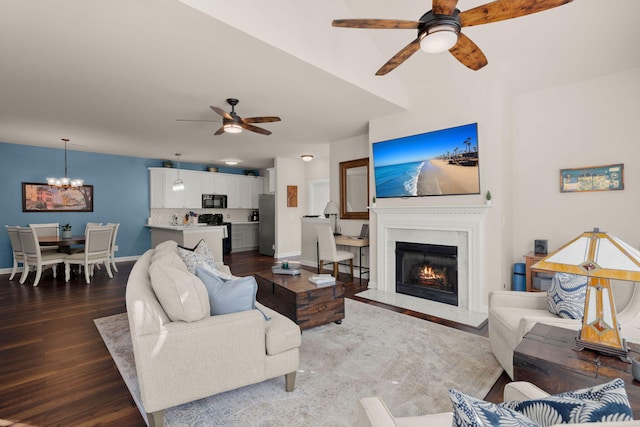 living room featuring wood-type flooring and ceiling fan with notable chandelier