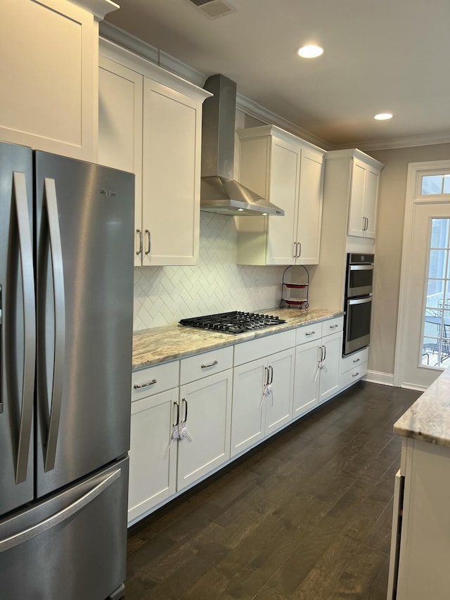 kitchen featuring stainless steel appliances, ornamental molding, wall chimney range hood, dark wood-style floors, and tasteful backsplash