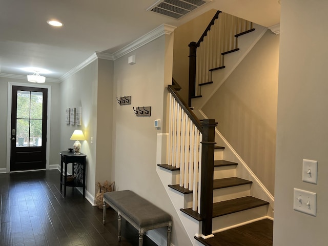 entryway with dark wood-style flooring, visible vents, baseboards, stairs, and ornamental molding