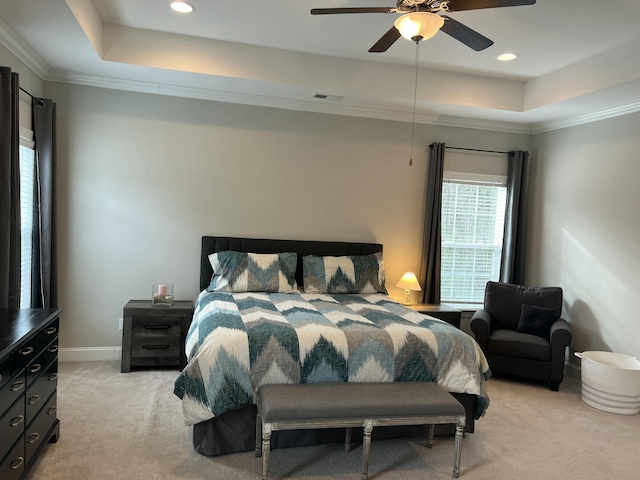 bedroom with light carpet, baseboards, visible vents, and a raised ceiling