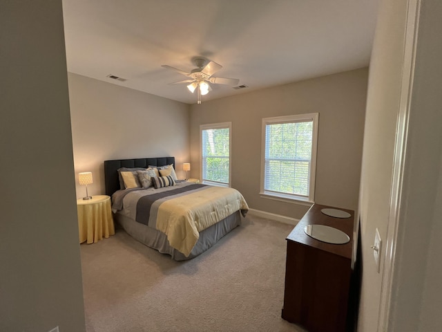 carpeted bedroom featuring ceiling fan, visible vents, and baseboards