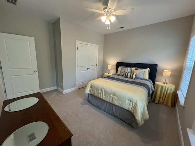 carpeted bedroom with a ceiling fan, visible vents, and baseboards