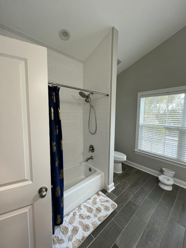 full bathroom featuring shower / tub combo with curtain, baseboards, vaulted ceiling, and toilet