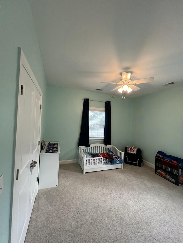 carpeted bedroom featuring a ceiling fan, visible vents, and baseboards