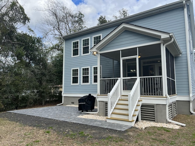 rear view of house featuring a sunroom