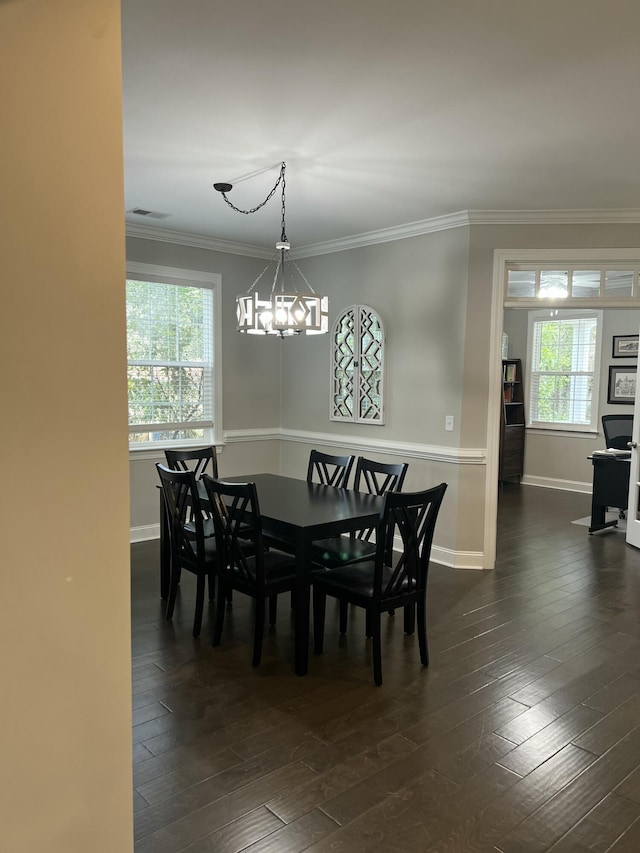 dining room with a notable chandelier, dark wood-type flooring, baseboards, and crown molding