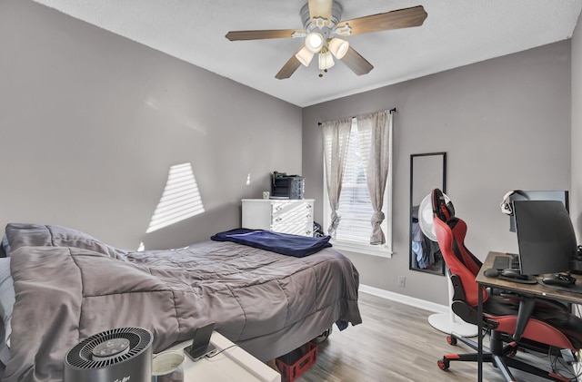 bedroom with ceiling fan and light hardwood / wood-style flooring