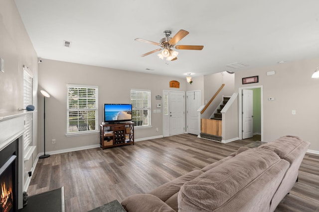 living room with dark hardwood / wood-style flooring and ceiling fan