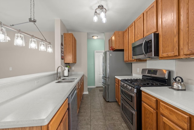 kitchen featuring pendant lighting, stainless steel appliances, dark tile patterned flooring, and sink